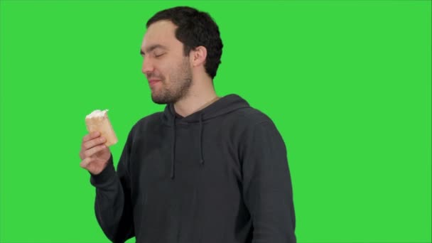 Przystojny młody mężczyzna jedzenie lodów na zielony ekran, Chroma Key — Wideo stockowe