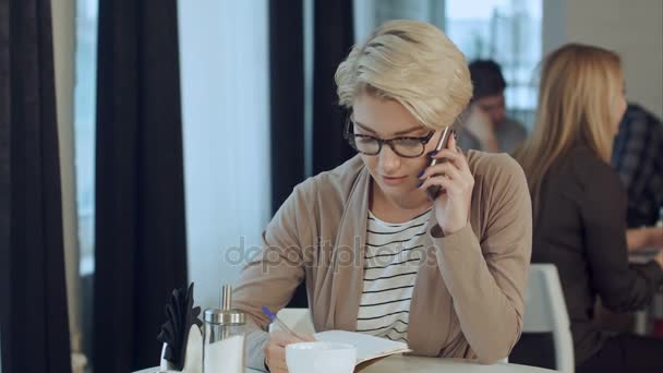 Szczęśliwa kobieta rozmawia przez telefon w kawiarni — Wideo stockowe