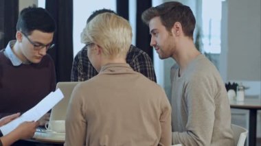 Modern bir stüdyoda beyin fırtınası yapan yaratıcı insanlar.