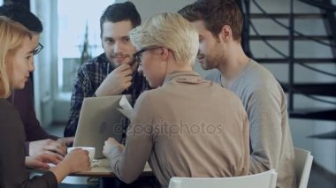 Grup ofis masada otururken gülümseme ile bir şey tartışırken beş insan