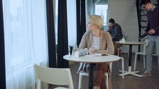 Gente disfrutando del café, trabajando y comunicándose en la cafetería por la mañana — Vídeo de stock