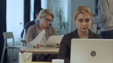 Modern ofis dizüstü bilgisayarda çalışan genç kadın