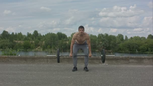 Hombre haciendo ejercicio al aire libre con barra de pesas — Vídeos de Stock