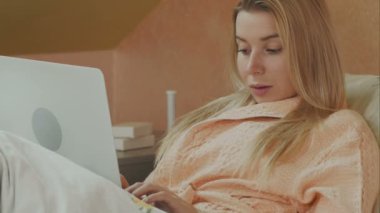 Bir dizüstü bilgisayar ile bir hastane yatağında yatan bir hasta