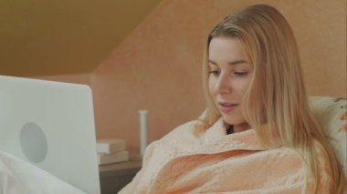 Hastane yatağında yalan görüntülü sohbet sahip dizüstü bilgisayar kullanan kadın odaklı