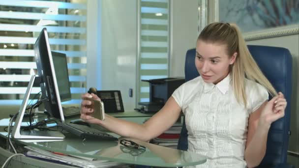 Kadın işçi ofiste otururken bir smartphone kullanarak selfie fotoğraf çekimi portresi — Stok video