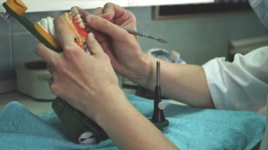 Diş teknisyeni takma diş bir neşter ile aşırı balmumu kaldırır