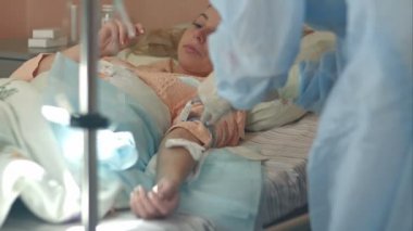 Eldiven hemşire ve hastane koğuşunda bir damla koyarak kadın hastaya maske