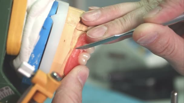 Lab technician removing imperfections from dental implant — Stock Video