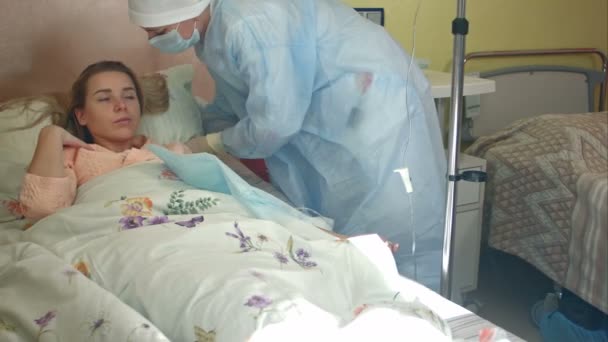 Enfermera atiende a una paciente joven, engordando su almohada después de poner gotero — Vídeo de stock