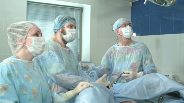Ομάδα των γιατρών που εργάζονται από κοινού κατά τη διάρκεια μια χειρουργική επέμβαση σε ένα λειτουργικό δωμάτιο σε νοσοκομείο — Αρχείο Βίντεο