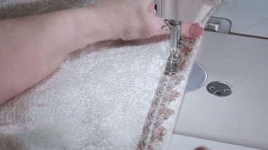 Beyaz pamuklu bir dikiş makinesi ile dikiş bir kadının görüntüleri
