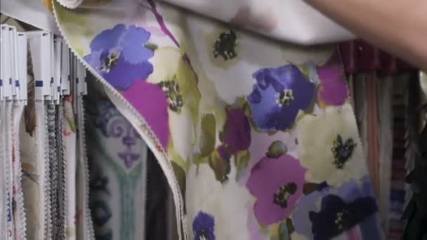 Vrouw kiest kladjes van gekleurde weefsel in winkel — Stockvideo