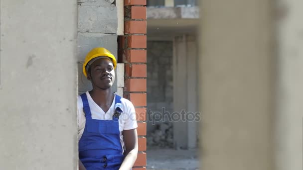 Молодой афро-американский строитель берет перерыв во время работы — стоковое видео