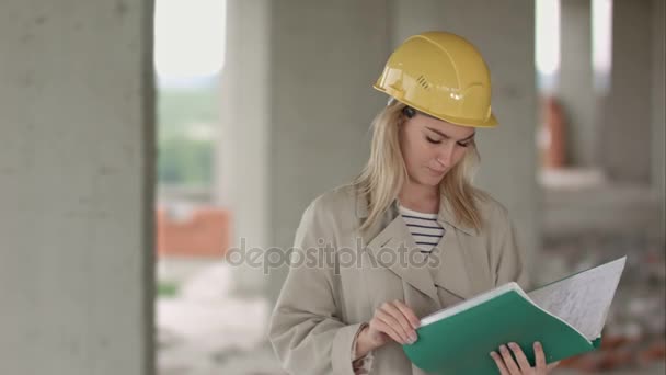 Fiatal női építész építőmérnök, egy építési telek eximaining dokumentumok — Stock videók