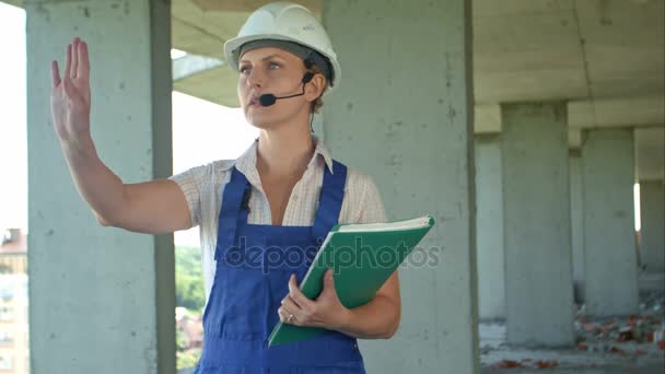 Une ingénieure en construction parle aux travailleurs par des liens internes — Video