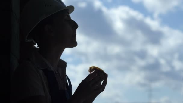 Construção trabalhador feminino comendo um sanduíche saboroso na hora do almoço de trabalho — Vídeo de Stock