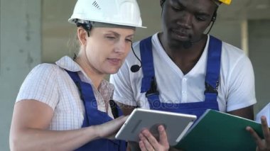 Konuşmayı ve tablet bilgisayar kullanarak iki işçi