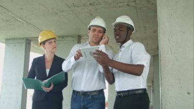 Tartışarak smartpone ve dijital tablet kullanarak proje, inşaat sitesindeki üst düzey yönetim ekibi