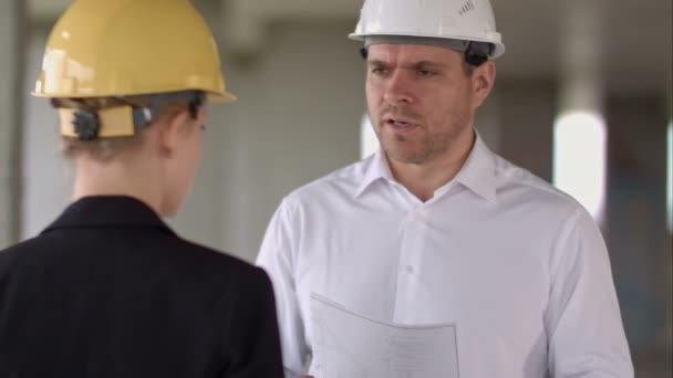 Construtor de equipe tem problema e irritado no prédio do canteiro de obras — Vídeo de Stock