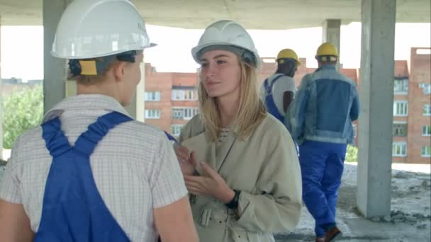 Arquitectura joven y trabajadora que habla en obra al aire libre — Vídeos de Stock