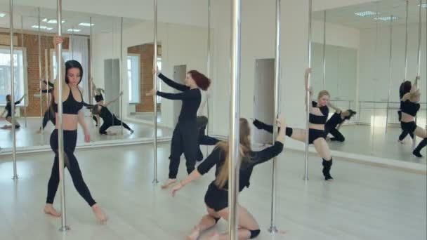 Grupp av spansktalande kvinnor stretching och värmer upp inför sin pole Dance class — Stockvideo