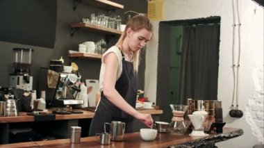 Güzel barista kahve bir fincan süt dökme kafede yapma