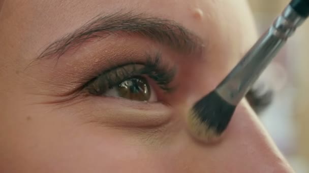Vynahradí krásná mladá dívka v salonu krásy použití očních stínů — Stock video
