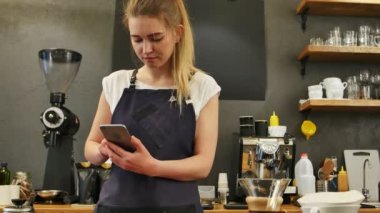 Cep telefonu iş yerinde kullanarak memnun kadın barista