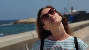 Sun üzerinde sahil yürüyüş zevk güneş gözlüklü genç kadın