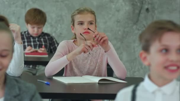 Schoolmeisje bril op te zetten tijdens de les — Stockvideo
