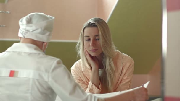 Молодая женщина-врач с пациенткой разговаривает в больнице — стоковое видео