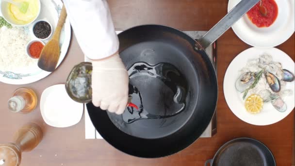 Olijfolie gegoten in de koekenpan uit de fles — Stockvideo