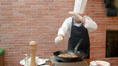 Şef sıkma limon suyu paella ile tava içine