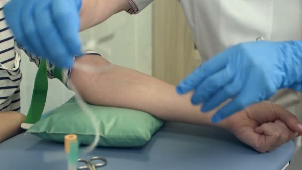 Sjuksköterska samla blod från patientens ven. — Stockvideo