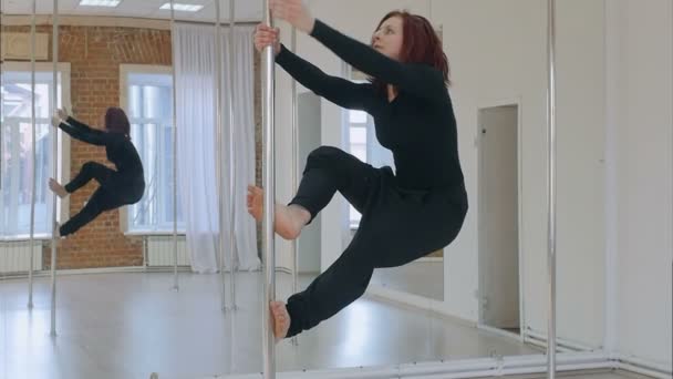 Спортивная танцовщица делает элемент на пилоне — стоковое видео