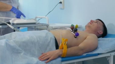 Hemşire erkek bir hastaya Ecg uyguluyor.