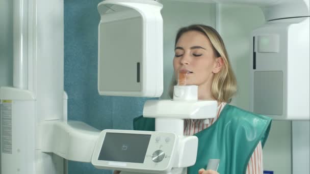 Пациентка проходит обследование на рентгеновском сканере зубов — стоковое видео