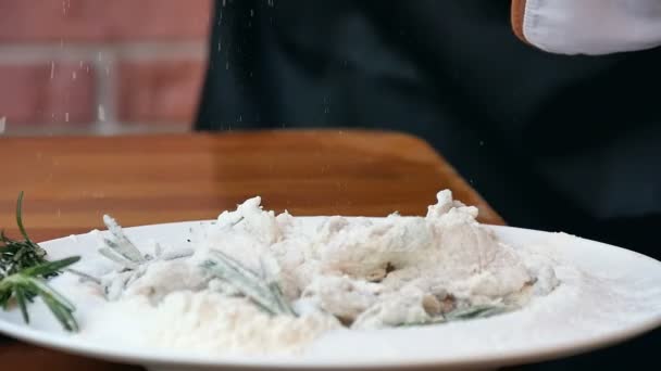 Посыпать соль на свежие морепродукты с мукой — стоковое видео
