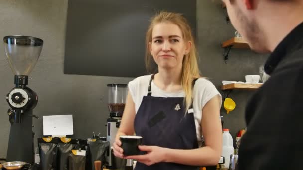 Официантка обслуживает клиента за стойкой в кофейне — стоковое видео