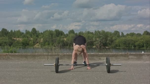 Молодая женщина с насосом для тела разрабатывает упражнения для задницы с штангой — стоковое видео