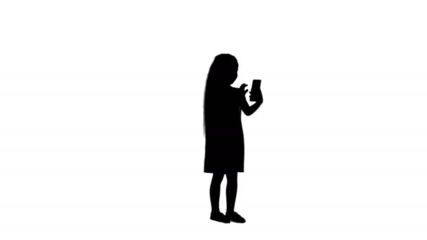 Silhueta menina bonito usa um smartphone e rir faixa fosco — Vídeo de Stock