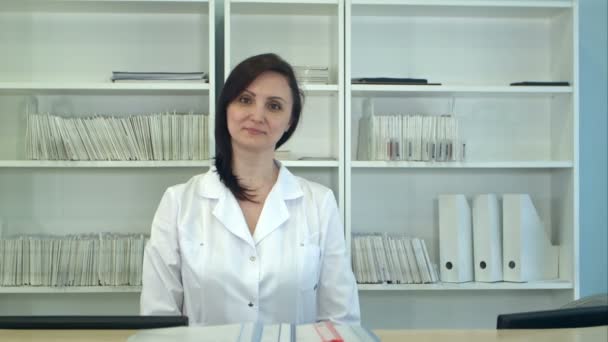 Vrouwelijke ziekenhuis receptioniste camera kijken — Stockvideo