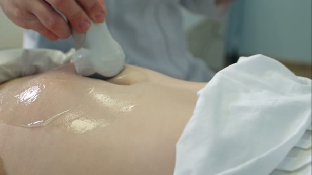 Врач перемещает ультразвуковой зонд на желудок беременной женщины — стоковое видео