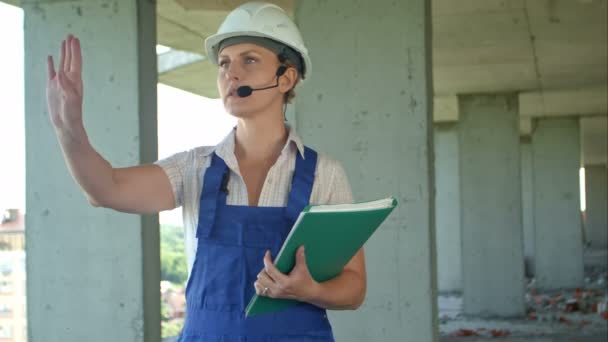 Vrouwelijke constructie engineer praat met werknemers via interne links — Stockvideo