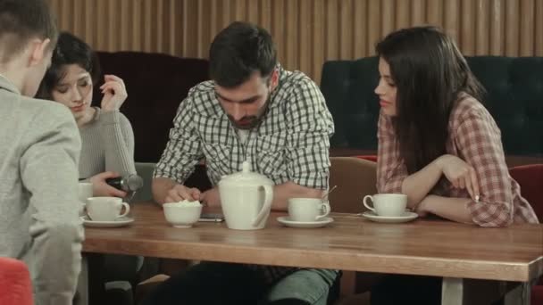 Grupo de jóvenes sentados en un café, hablando y tomando té — Vídeo de stock