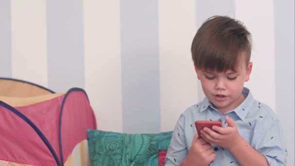 Muchacho emocionado leyendo un mensaje en su teléfono — Vídeos de Stock