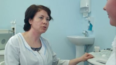 Deneyimli kadın doktor hasta hastanede konuşurken