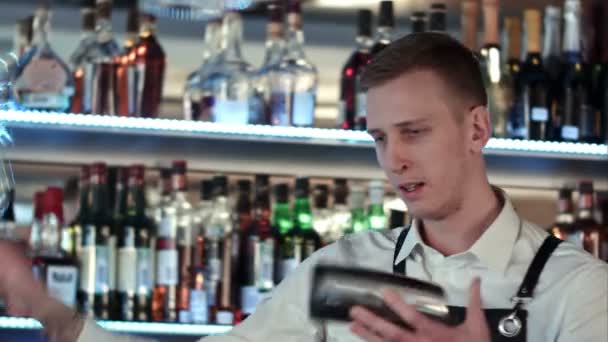 Jonge professionele barman in actie met de shaker en fles cocktail drinken maken — Stockvideo