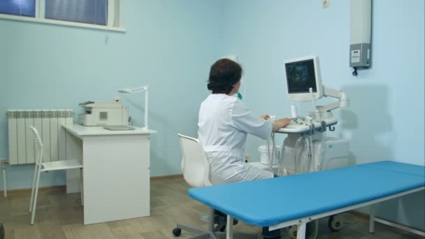 Mujer médico trabajando en la máquina de diagnóstico por ultrasonido — Vídeos de Stock